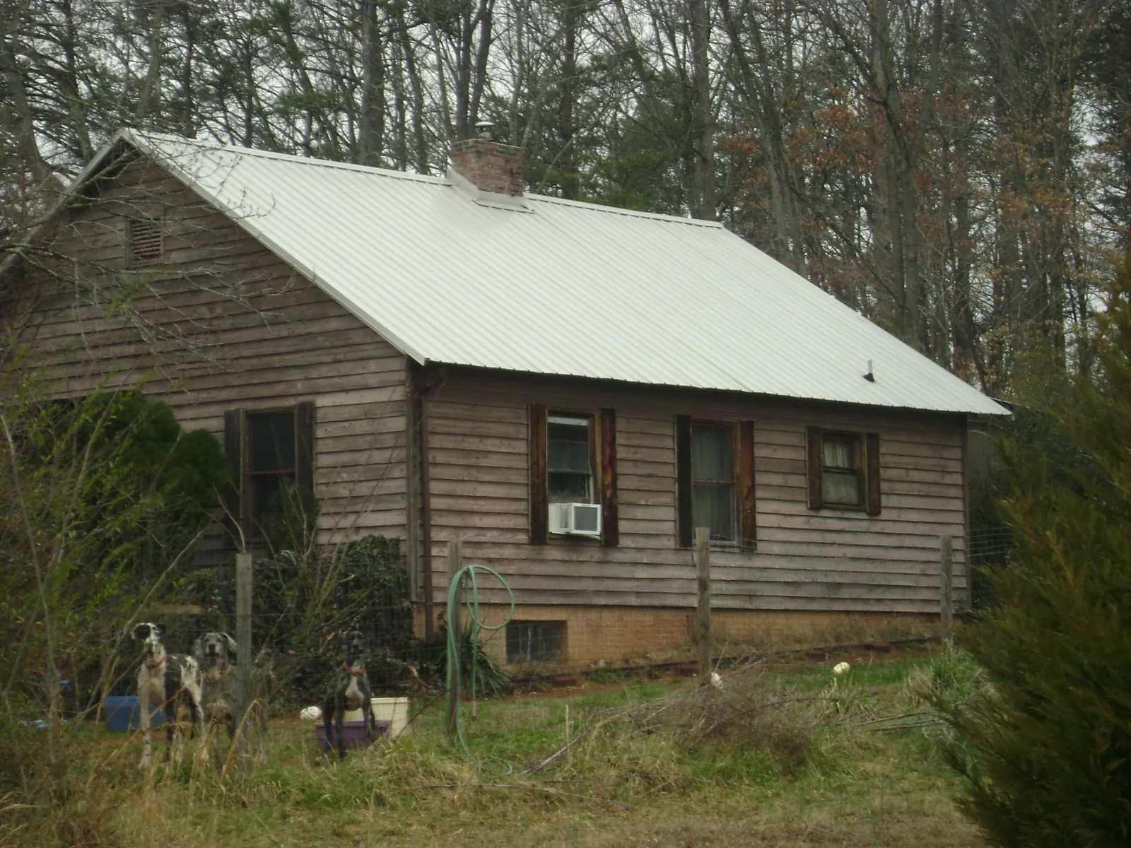White metal roof on an old wood sided farmhouse, from a Metal Roof Installation job in Saltillo